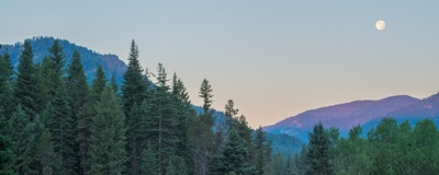 The evening moon shines above the Minam River Lodge