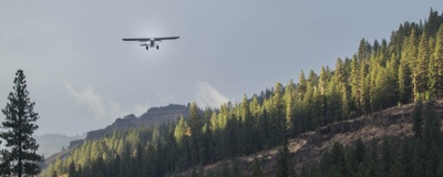 A small prop plane descends to land at the Minam River Lodge.